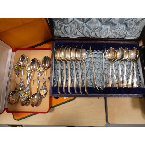 134 - Boxed cutlery to include souvenir spoons, butter knives, teaspoons and tongs etc.