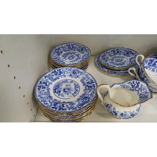 202 - Minton 'Claremont' pattern tablewares decorated with blue and white scrolls (one shelf).