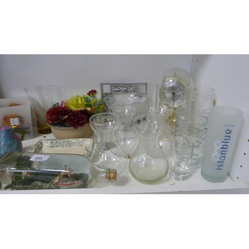 223 - Ship in a bottle, glassware, mantel clock, candles etc (one shelf).