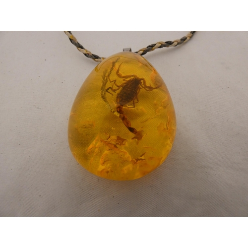 284 - Synthetic amber-style pear-shaped pendant on chain.