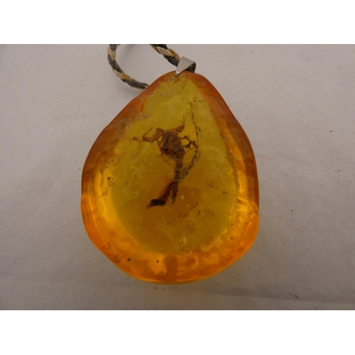 284 - Synthetic amber-style pear-shaped pendant on chain.