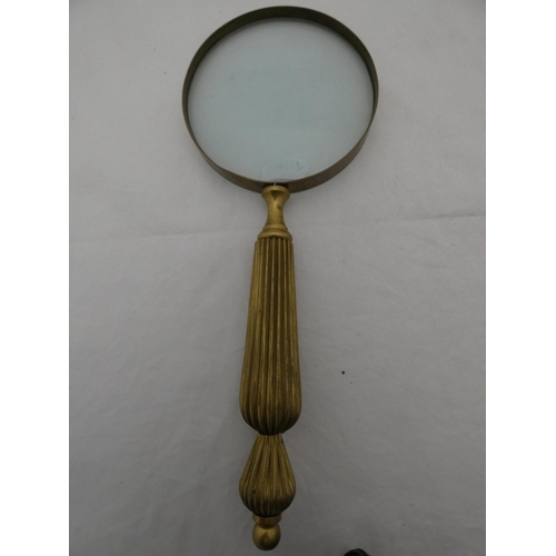 310 - Three brass-mounted magnifying glasses, one with a bone handle.