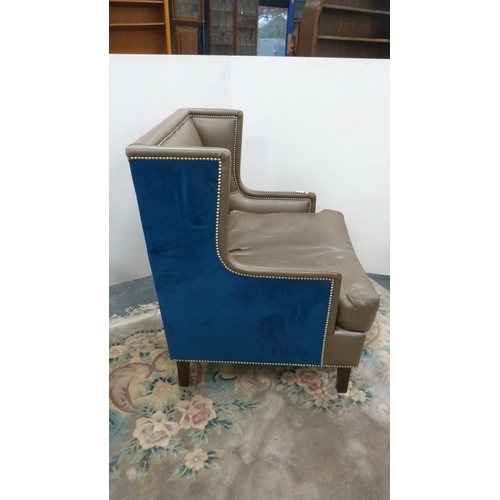 405 - Contemporary wing armchair upholstered in blue velour and hide.