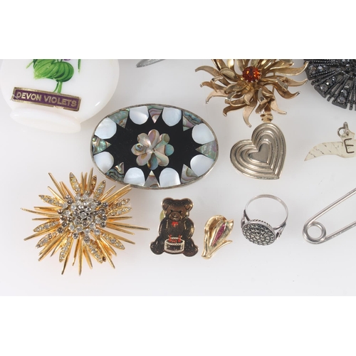 524 - Costume jewellery brooches, badges etc.