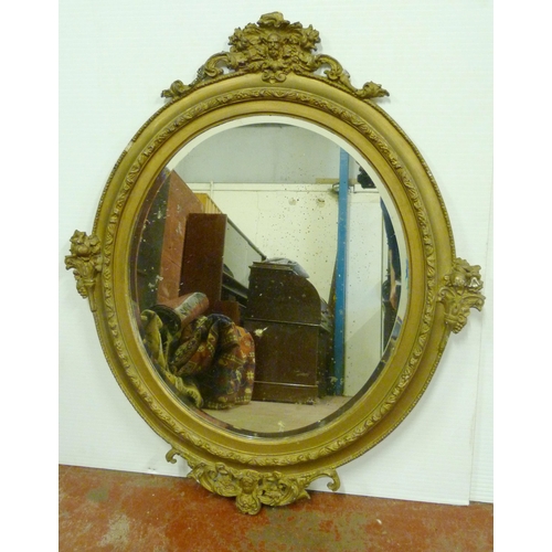 502 - 19th century mahogany gilt wood and gesso wall mirror, the oval plate glass mirror decorated with sc... 