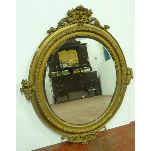 502 - 19th century mahogany gilt wood and gesso wall mirror, the oval plate glass mirror decorated with sc... 