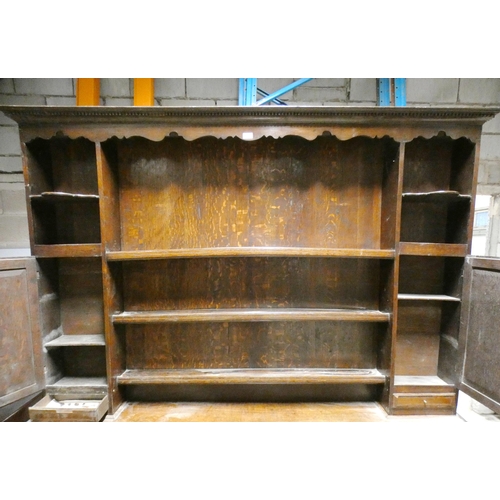 555 - Victorian oak dresser, the top section with open Delft rack flanked by open shelving, above cupboard... 