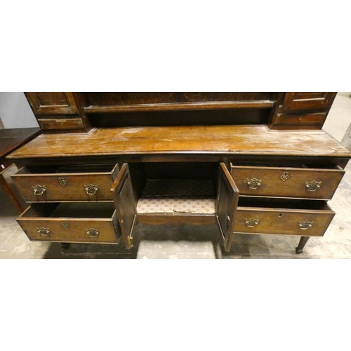 555 - Victorian oak dresser, the top section with open Delft rack flanked by open shelving, above cupboard... 