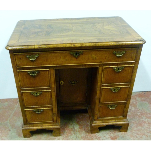 560 - George III walnut and feather banded kneehole desk with a frieze drawer above indented central cupbo... 