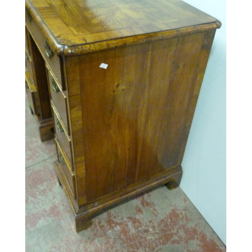 560 - George III walnut and feather banded kneehole desk with a frieze drawer above indented central cupbo... 