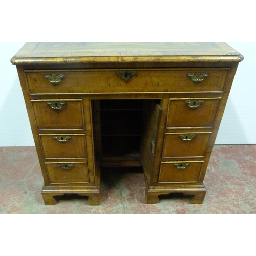 560 - George III walnut and feather banded kneehole desk with a frieze drawer above indented central cupbo... 