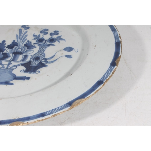 152 - 18th century tin glazed blue and white charger decorated with vases of flowers, 37.5cm diameter.