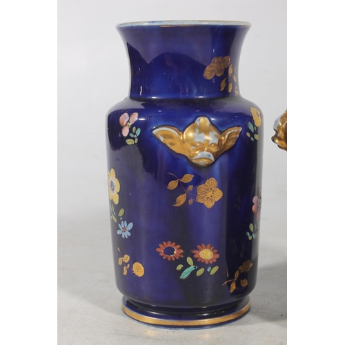 192 - Pair of European porcelain vases, the deep blue ground decorated with flowers, 15cm tall.