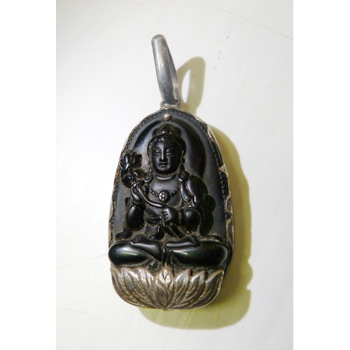 374 - South East Asian black obsidian pendant, carved with profile of the goddess Guanyin, mounted in whit... 