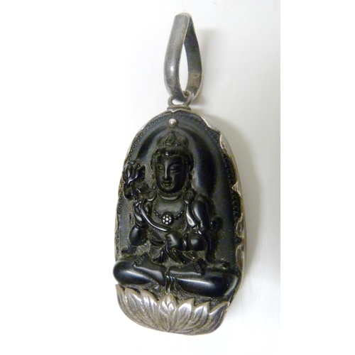 374 - South East Asian black obsidian pendant, carved with profile of the goddess Guanyin, mounted in whit... 