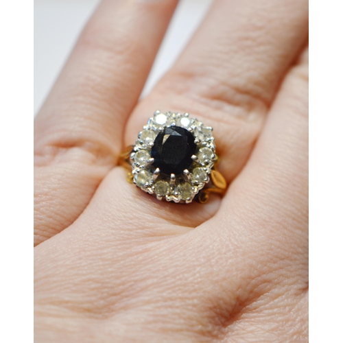 247 - 18ct gold gem set and diamond lady's cluster ring, baguette-cut, with a central dark stone that has ... 