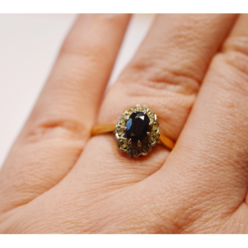 249 - 18ct gold sapphire and diamond lady's cluster ring, the oval sapphire flanked by small brilliants, s... 