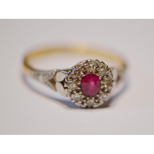 250 - 18ct gold ruby and diamond lady's cluster ring in a flowerhead setting with central small ruby, flan... 