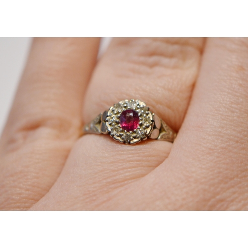 250 - 18ct gold ruby and diamond lady's cluster ring in a flowerhead setting with central small ruby, flan... 