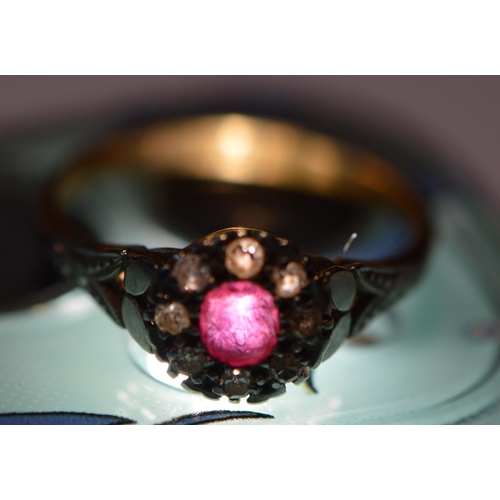 250 - 18ct gold ruby and diamond lady's cluster ring in a flowerhead setting with central small ruby, flan... 