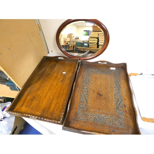 153 - Two oak trays and a mahogany oval wall mirror.