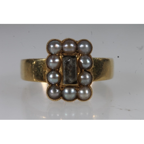 22 - Early 20thC yellow metal and seed pearl mourning ring, the central glazed panel enclosing woven hair... 