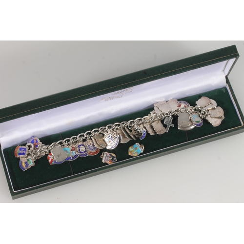 25 - Silver and enamel souvenir charm bracelet, the charms decorated with British and European civic hera... 