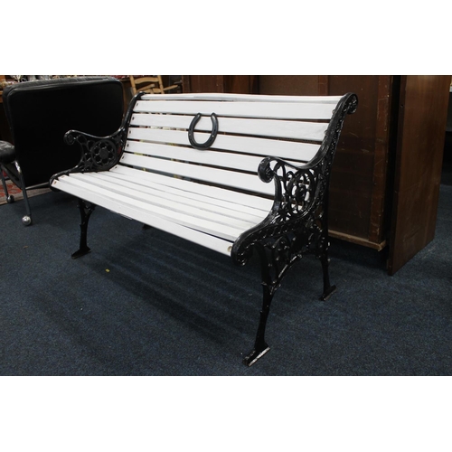 31 - Cast iron and wooden slat garden bench, the pierced wrought iron sides with foliate scroll decoratio... 