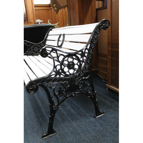 31 - Cast iron and wooden slat garden bench, the pierced wrought iron sides with foliate scroll decoratio... 