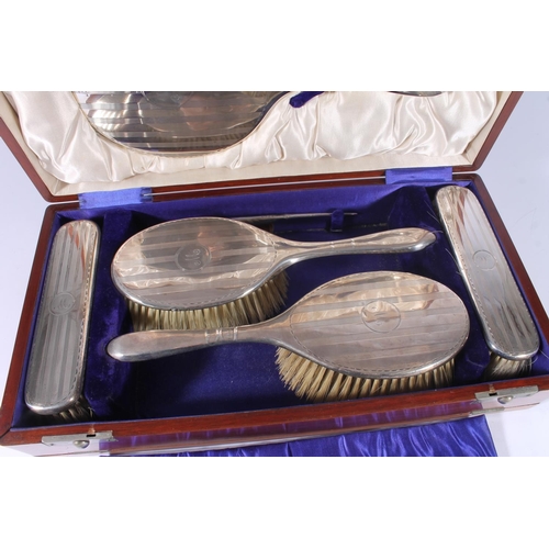 16 - Geo.V silver dressing table set, of four brushes, hand mirror and comb, all with lined engine turned... 