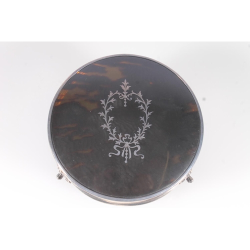 50 - Geo.V silver and tortoiseshell dressing table box, of round form with inlaid cover and on three Quee... 