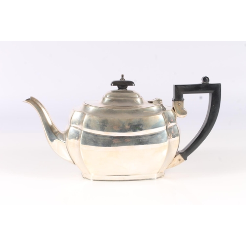 53 - Geo. V silver three piece tea set, the teapot with angular ebonized handle on a stepped oval body wi... 