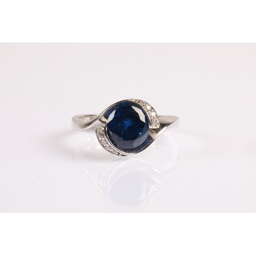 61 - Silver ring set with a large blue gem flanked by small white gems, Size P, 3.8g