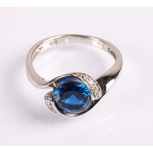 61 - Silver ring set with a large blue gem flanked by small white gems, Size P, 3.8g