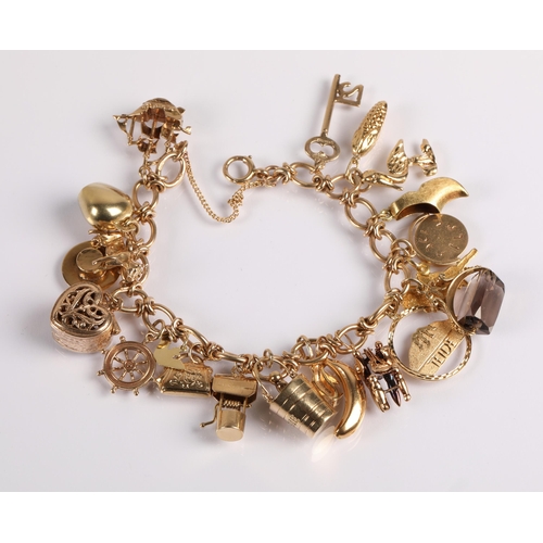 64 - 9ct gold charm bracelet with twenty charms, mainly gold, 41g gross