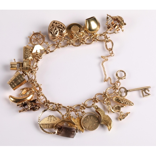 64 - 9ct gold charm bracelet with twenty charms, mainly gold, 41g gross