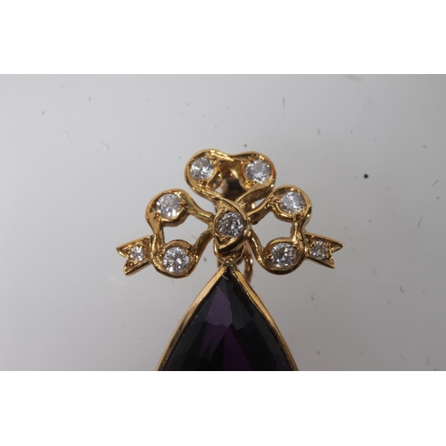 112 - 18ct gold mounted pendant set with faceted tear drop shaped amethyst surmounted by a bow set with sm... 