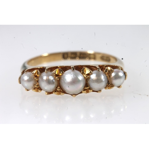 129 - Early 20thC 18ct gold and pearl ring, the graduating pearls in a shared claw setting on a plain tape... 