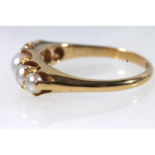 129 - Early 20thC 18ct gold and pearl ring, the graduating pearls in a shared claw setting on a plain tape... 