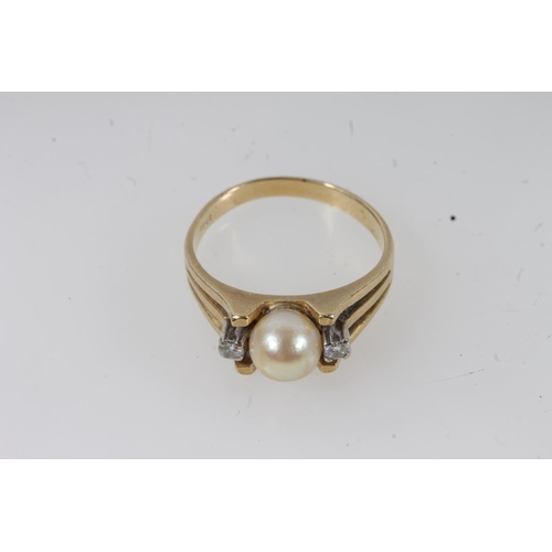 130 - 18ct gold solitaire pearl ring, the round pearl flanked by two small round cut diamonds on a split t... 