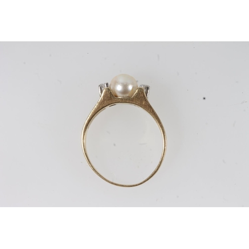 130 - 18ct gold solitaire pearl ring, the round pearl flanked by two small round cut diamonds on a split t... 