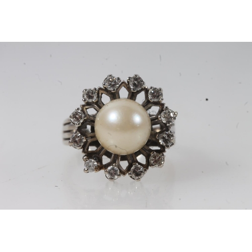 131 - 14ct white gold and solitaire pearl ring, the round pearl within a halo of round cut diamonds on a s... 