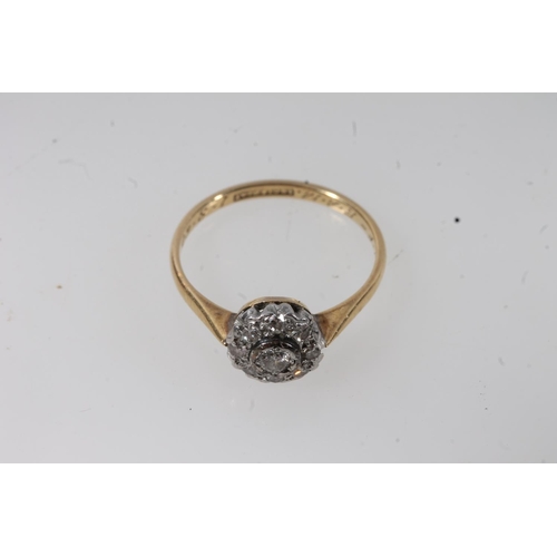 135 - 18ct gold diamond cluster ring, the principal round cut diamond bezel set within a halo of prong set... 