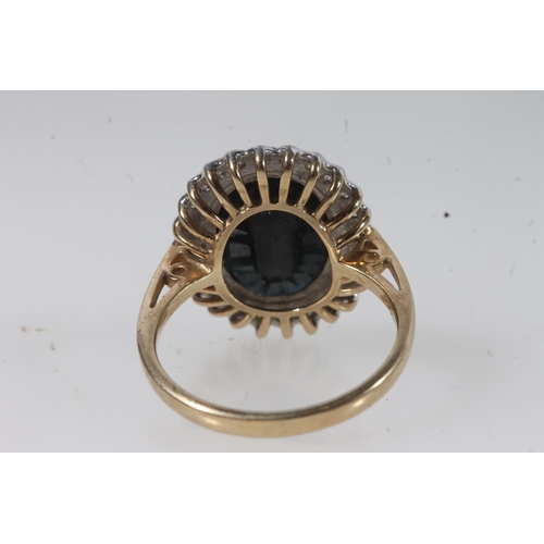 138 - 9ct gold sapphire and diamond cluster ring, the large oval cut dark sapphire within a halo of small ... 