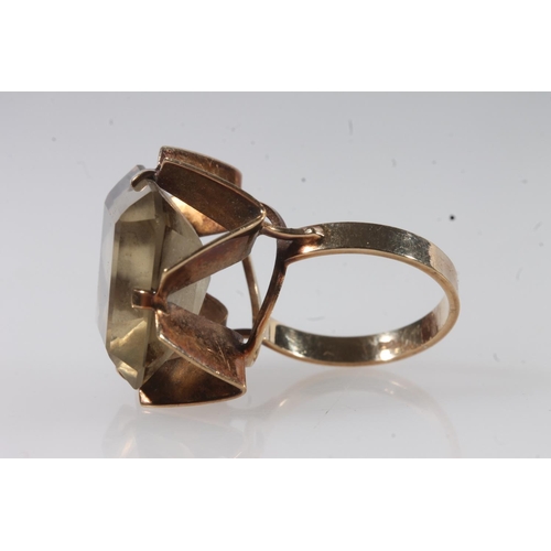 141 - 9ct gold and yellow stone modernist ring, the large citrine coloured stone on a geometric pierced mo... 