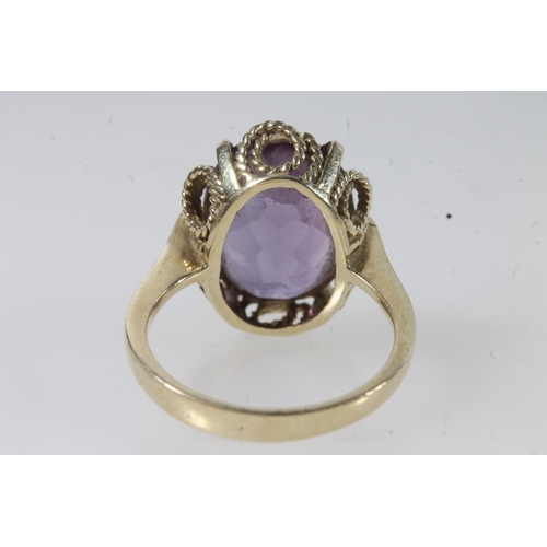 144 - 14ct gold amethyst ring, the large oval cut amethyst on a pronged rope twist filigree setting on a p... 