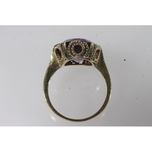 144 - 14ct gold amethyst ring, the large oval cut amethyst on a pronged rope twist filigree setting on a p... 