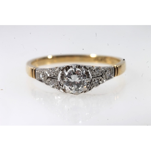 177 - 18ct gold and platinum solitaire diamond ring, the round cut brilliant in a claw setting, flanked by... 