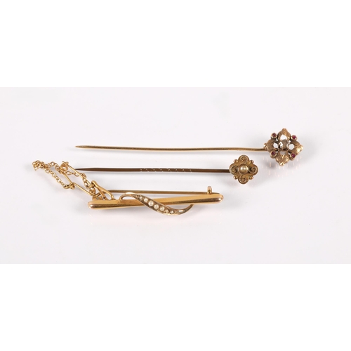 100A - Stick pin set with a seed pearl, head marked 9ct, another yellow metal set with a diamond and four p... 