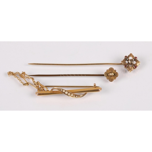 100A - Stick pin set with a seed pearl, head marked 9ct, another yellow metal set with a diamond and four p... 